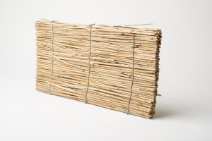 Reeds woven together with wire to form a board