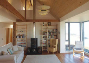 double height living room with wood burner and timber clad ceiling