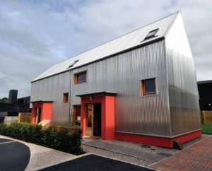 silver corrugated house with red wall and doors