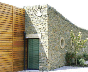 timber wall next to slate wall with porthole windows