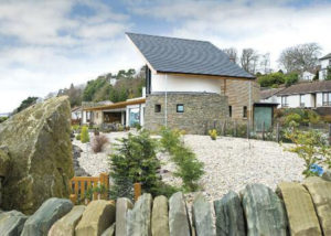 curved slate wall house with rockery garden