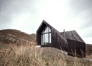 faceted black timber building on a hill