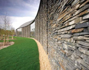 stacked slate curved wall of a building with large glazed windows
