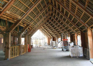 long curved timber roof structure under construction