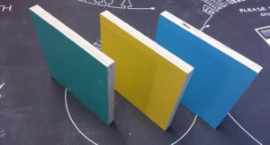 three painted timber squares on a blackboard table