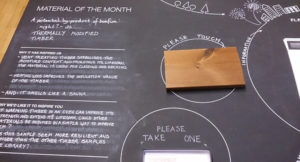 blackboard with a piece of timber and material of the month on it