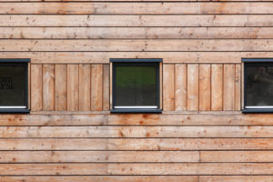 timber clad wall with three small square windows