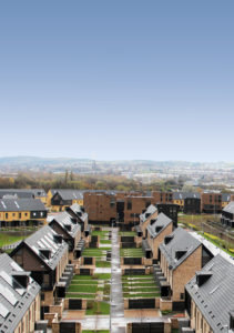 two rows of houses from the athletes village with other new housing in the background