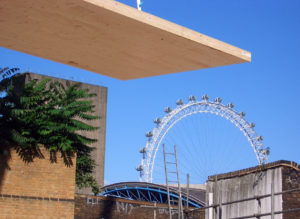 Large clt panel being craned onto a site with the London Eye and some block shaped buildings in the background