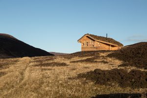 barron hillside with a timber bothy with an arrangement of small odd shaped windows