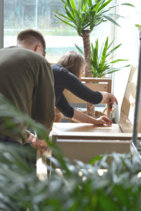 male and female putting together a sofa with plants in the background and foreground