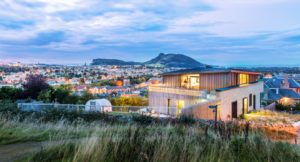 illuminated timber building with a vew to Arthurs Seat in Edinburgh, the city of illuminated